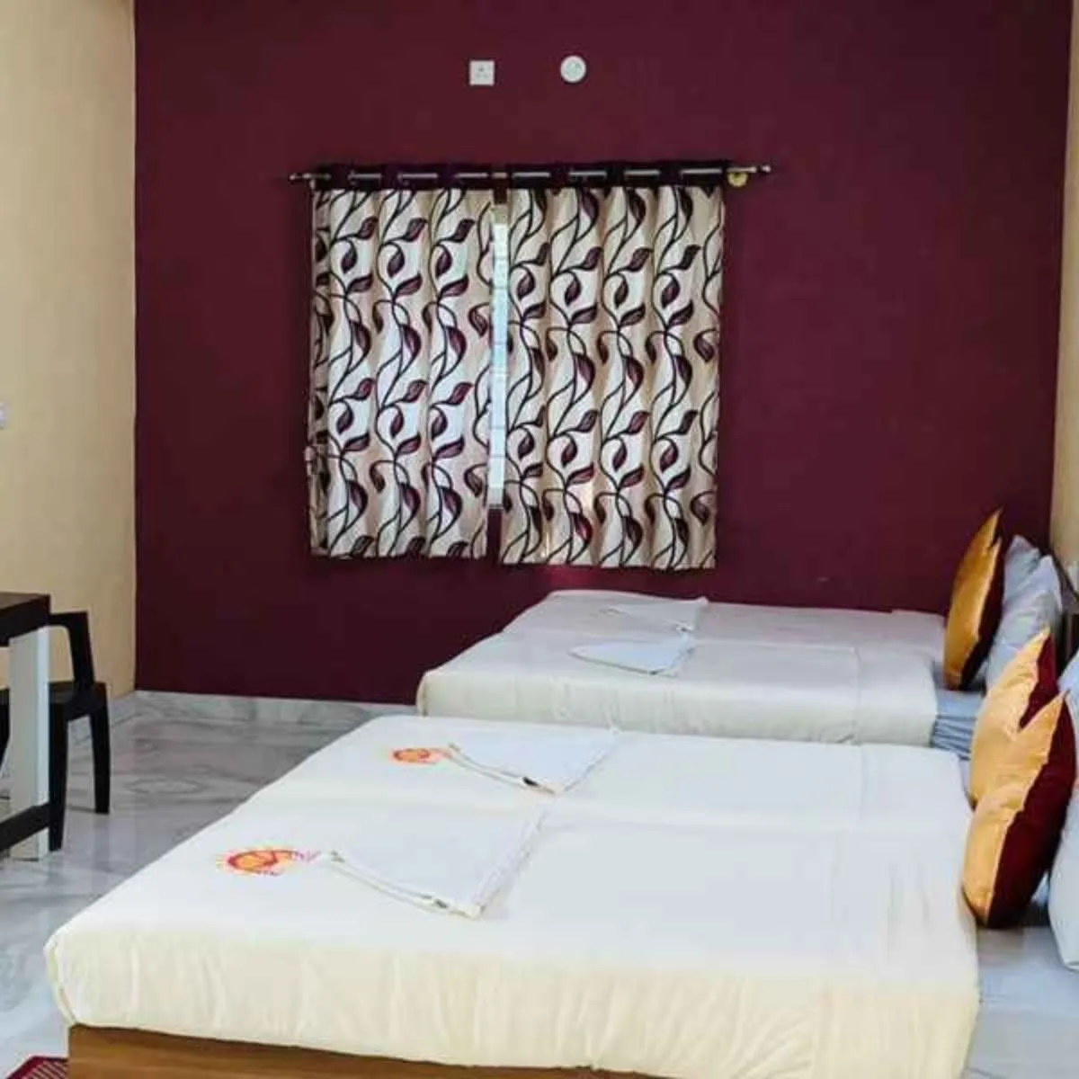 Malgoba room beds with wall art and maroon accent wal